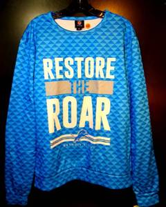 lot 168 image: NFL TEAM APPAREL - DETROIT LIONS LONG SLEEVE RESTORE THE ROAR LIGHT FLEECE