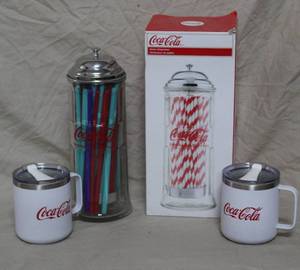 lot 110 image: 2- Coca-Cola cups with lids and a glass Coca-Cola straw holder