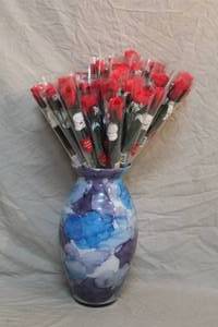 lot 147 image: glass vase full of individually wrapped flowers each with bear