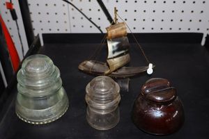 lot 42 image: Glass insulators, Brown ceramic insulator, and sail ship model