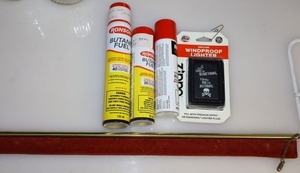 lot 109 image: Zippo lighter, Butane fuel bottles, and long brass lighter