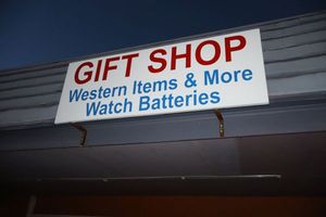 lot 627 image: Metal store front sign - must bring tools and ladder to remove