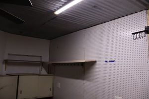 lot 607 image: Peg boards (2 full sheets) with two shelves, brackets, and power strip cord - must bring tools to remove anytime
