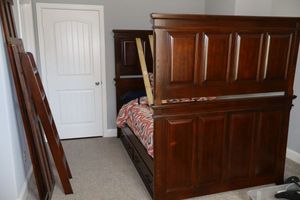 lot 143 image: Full size wood bunk beds with trundle, see all photos. 61W x 82L. This item is upstairs, HEAVY, bring help