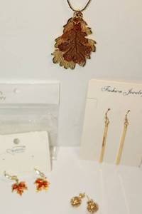 lot 18 image: Leaf pendant necklace, love knot earrings, gold-plated, and red crystal maple leaf hoop earrings by the brand Sonateomber.