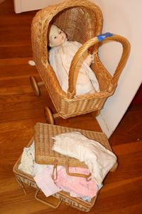 lot 5 image: Wicker stroller and suitcase with doll and doll clothes