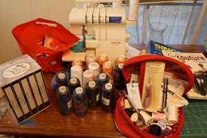 lot 7 image: Singer sewing machine , thread spools, and sewing books