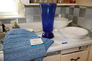 lot 236 image: Blue glass vase, white serving bowls, and blue kitchen rugs