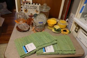 lot 241 image: Sunflower Pyrex bowls, green kitchen rugs, clear pumpkin jar and more