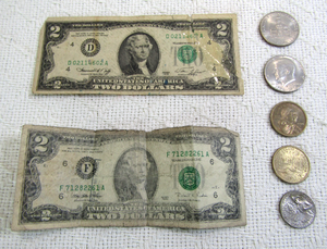 lot 568 image: Collectible cash - Bicentennial Kennedy half dollars (2), Bicentennial quarter, Bicentennial 2 dollar bill, Sacagawea dollars (2), 1995 2 dollar bill
