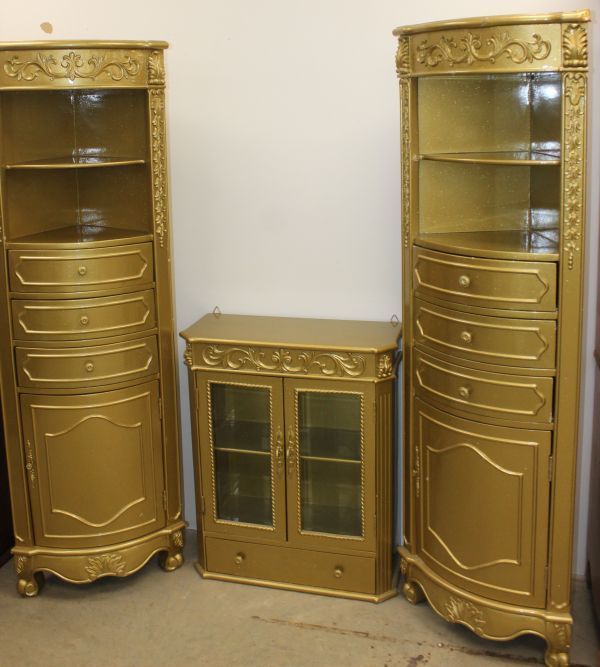 lot 102 image: Vintage Louis XVI Style Corner Cabinets and matching Wall Cabinet and Michael Amini Lisbon Nesting Tables Featuring a triangular design with ribbed gold finished trim Charlie Not Included