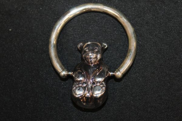 lot 20 image: Vintage Tiffany &amp Co. Sterling Silver Teddy Bear Rattle Featuring a Spinning Bear Design. The Bear and Ring are both Stamped Sterling 925. It measures approximately 3.25 inches by 2.5 inches.&nbsp