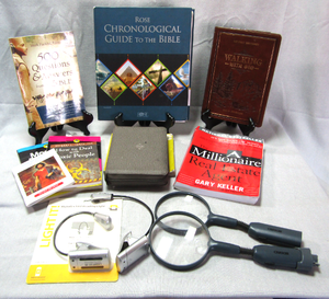 lot 6 image: Assorted books, Holy Bible, Millionaire real estate agent and more, includes reading lights and magnifying glasses