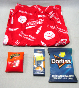 lot 108 image: Cheetos Bluetooth speaker, Doritos cool ranch eye shadow pallete & nail polish set, Coca-Cola boxers