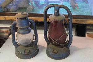 lot 96 image: vintage collectible is a Dietz Monarch kerosene lantern featuring a blue metal frame and a distinct red glass globe.  And  Dietz Little Wizard oil burning lantern, featuring a blue metal frame.