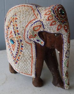 lot 195 image: handmade, hand-carved decorative elephant figurine, adorned with beaded or jeweled mosaic details on its back and head.  About 10 to 11 inches tall