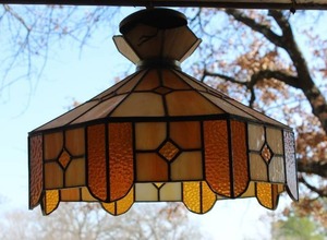 lot 215 image: vintage Tiffany-style hanging light, often featuring amber, orange, or yellow stained glass panels