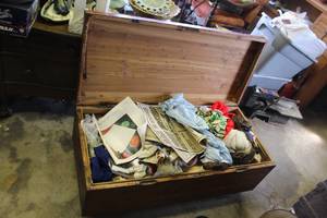 lot 240 image: Trunk full of hand made baby clothes and patterns a mix of things trunk has small crack on the lid see pictures for details