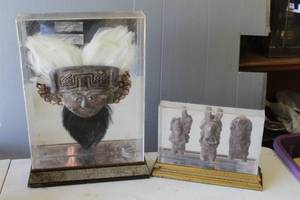lot 322 image: Tatanua helmet mask,  in shadow box and decorative set of three ceramic figurines in shadow box