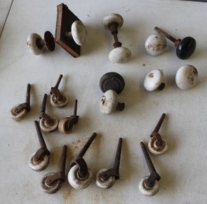 lot 634 image: antique white porcelain doorknobs, likely dating from the late 1800s to the early 1900s.  And vintage furniture casters featuring white porcelain or ceramic wheels.