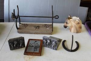 lot 678 image: Hand made horseshoe paper towel holder  and horse bookends and horseshoe hook and horse vase and plaque featuring a Western-themed sketch of a cowboy