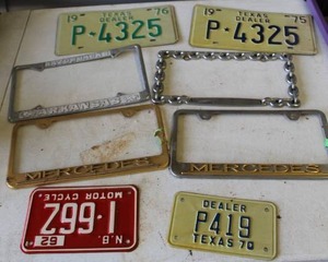 lot 720 image: collection of vintage license plates and automotive dealer frames.