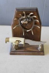 lot 825 image: decorative collectible set featuring a resin-sculpted dagger with a deer-themed handle displayed on a matching faux-antler stand