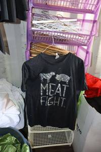lot 56 image: Plastic stackable storage bins with clothes hangers and Meat Fight T-shirt