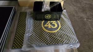 lot 129 image: Lot of Licor 43 Bar Supplies.  Includes Bar Mats (Qty 2), StrawNapkin Caddy & Gold Stir Spoon