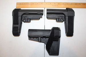 lot 85 image: Three pistol stabilizers - one Blade and two Shockwave braces as shown