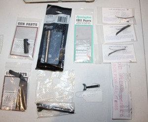 lot 225 image: Gun parts as shown 5 38 Super extra barrel, 1911 belt clip, fiber optic sights, 38 super trigger, sear springs