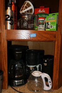lot 110 image: Coffee makers, extra coffee pots, can opener, filters, and coffee pot cleaner