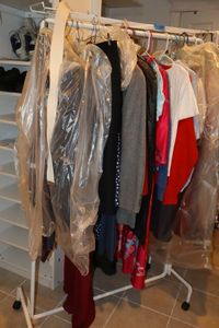 lot 267 image: Rolling clothes rack with clothes as shown