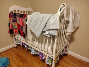lot 304 image: Rolling white crib with blankets