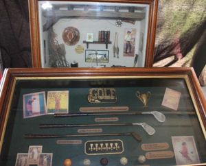 lot 44 image: Vintage History of golf shadow box display featuring miniature Clubs, balls and other memorabilia