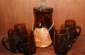 lot 57 image: Vintage Amber glass set, includes a Spanish porron Decanter with wooden lid and ice lip and matching mugs. Seven Piece Set