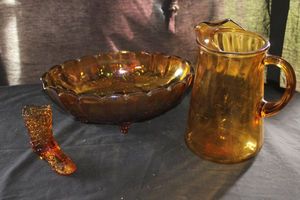 lot 58 image: Vintage Indiana Glass Amber Sunflower Serving Bowl and Amber Glass Pitcher From Liberty Glass Company, Featuring a Swirl Pattern and an Ice Lip.. A Vintage Fenton Art Glass Boot in the Daisy and Button Pattern