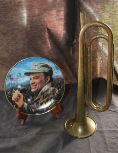 lot 66 image: A Brass Bugle and Decorative Ceramic Plate Featuring A Portrait of Bob Hope.