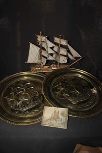 lot 75 image: Vintage Brass Wall Plates Featuring Embossed Ship Designs and a Model Sailing Ship