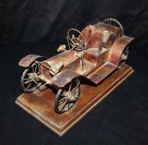 lot 122 image: Vintage Handmade Sculptured Copper musical Car, Likely a 1910 Ford Model, mounted on a wooden base