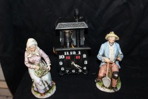 lot 130 image: Vintage Spartus Pot Belly Stove Clock alongside two porcelain Homco figurines model numbers 1433 and Old World Farmer man with a pipe and shovel style number 1433
