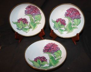 lot 205 image: Three Vintage hand-painted in Hong Kong plates, featuring a hydrangea pattern and a brass rim.