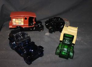 lot 227 image: Four Vintage Avon Glass Decanters Blue Glass Stanley Steamer Automobile, Big Mack Truck, Stagecoach, and Country Vendor ford Model T Delivery truck