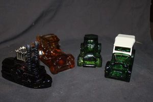 lot 229 image: Four Vintage Avon Decanters Green Glass Maxwell car, Green Glass Big Mack, Amber Glass 1970 Packard Roadster, Steam Powered Riverboat&nbsp
