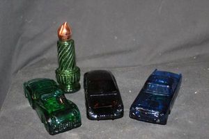 lot 230 image: Four Vintage Avon Decanter Bottles 1955 Thunderbird, 1968 Black Porsche 911, 1956 Triumph TR3, 1970s Perfume Bottle Shaped Like a Christmas Candle