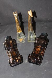lot 278 image: Four Vintage Collectible Avon Perfumeaftershave decanter bottles Two GlassGiraffe bottles and Amber colored Sterling Six car, designed to mimic a 1917 Automobile, and Amber colored Convertible Sedan Circa 1970s