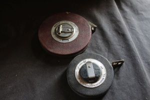 lot 279 image: Two Vintage tape measures, collectible measuring tools, commonly 50-100 feet in length