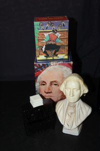 lot 362 image: Two Vintage Avon Decanters with Original boxes. George Washington Bust made of Milk Glass with Plastic cap, Piano Decanter from 1972 made of Dark Amber glass with plastic cap.