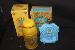lot 371 image: Two Avon Decanter Bottles with Original Boxes. Blue Milk Glass cuckoo clock bottle and Yellow Milk Can&nbsp with Floral pattern.