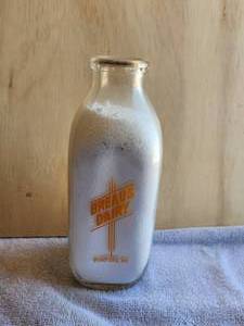 lot 84 image: Vintage square glass milk bottle - Breaus Dairy Rumford, ME. - Quart - with rare milk cap